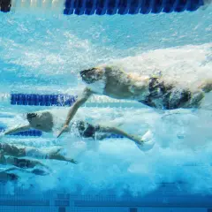 Nuotatori in gara, un'ispirazione per chi vuole imparare a nuotare. L'acqua turbolenta mostra la potenza e la velocità.