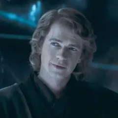 Hayden Christensen som Anakin Skywalker, med ett ärr över ögat och ett snett leende, blickar ut i mörkret.