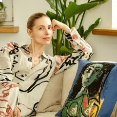 Katarzyna Zawadzka w domowym zaciszu, relaksująca się na kanapie obok poduszki z motywem Picassa. Jej życie prywatne pełne jest sztuki i spokoju.