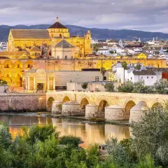 Puente Romano y Mezquita-Catedral de Córdoba, un ave que vuela sobre la historia, evocando un viaje desde Barcelona.