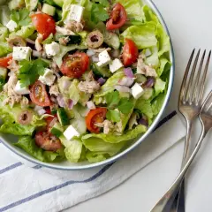 Insalata fresca con lattuga, pomodorini, cetrioli, olive, cipolla rossa, cubetti di feta e tonno sminuzzato.