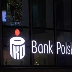 Świecący napis PKO Bank Polski. W tle choinka i odbicia. Inwestorzy liczą na dywidendę PKO BP.