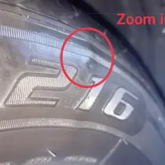 Un bulto en el neumático, marcado con un círculo rojo, indica un posible daño.