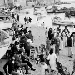 Gente en la playa con barcos, un vistazo al posible origen del conflicto entre Israel y Palestina.