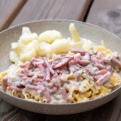 En skål med krusig pasta och skinksås, serverad med blomkål. Enkel och god vardagsmat.