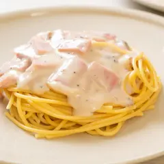 Pyszny makaron spaghetti z kremowym sosem śmietanowym i kawałkami szynki. Idealny sos śmietanowy do makaronu.