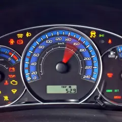 Deska rozdzielcza Ford Kuga z wieloma kontrolkami, w tym ABS, poduszka powietrzna i ostrzeżenie o niskim poziomie paliwa.