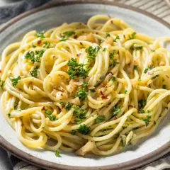 Pyszne spaghetti aglio e olio z natką pietruszki i płatkami chili. Idealne danie z listy 10 pomysłów na obiad.