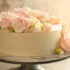 Elegancki tort udekorowany kremowymi różami w odcieniach różu i bieli. Idealny na każdą okazję, dzięki niezawodnemu kremowi do tortu, który zawsze się udaje.