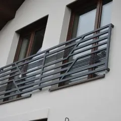 Nowoczesne balkony francuskie z metalową, geometryczną balustradą zdobią elewację domu.