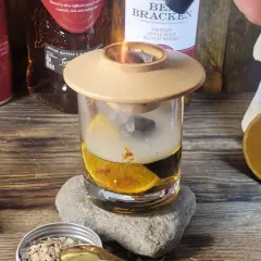 Dymiący drink z whisky, pomarańczą i kamieniami do napojów. Idealny sposób, jak zrobić drinka z whisky, by nadać mu głębi smaku.