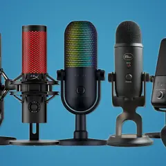 Mehrere Mikrofone für PC-Tests, darunter Modelle von SteelSeries, HyperX, Razer, Blue und Shure, stehen nebeneinander.