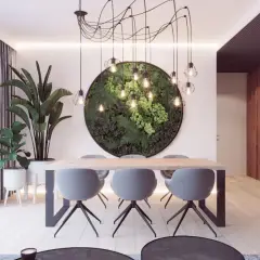 Nowoczesny salon z jadalnią, gdzie centralnym punktem jest okrągła ściana z zieleni i nietypowy żyrandol pajęczyna.