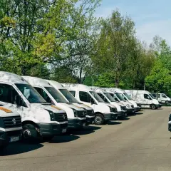 Rząd białych busów do 3,5 tony gotowych do stałych zleceń.