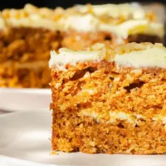 Wilgotne ciasto marchewkowe z kremowym lukrem, idealne na dietę. Pyszny kawałek na talerzyku.