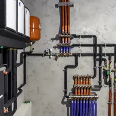 System hydrauliczny z bojlerem, pompą ciepła i rozdzielaczami ogrzewania podłogowego.