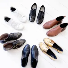 Collection de chaussures variées : baskets blanches, bottines cloutées, mocassins dorés, bottines noires, derbies vernies et bottines marron. Une vraie panoplie de chaussure qui va avec tout !