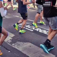 Läufer im Rennen, die ihre aerobe Ausdauer unter Beweis stellen. Bunte Laufschuhe und sportliche Kleidung.