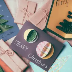 Biglietti di Natale fai da te originali con alberi 3D e decorazioni colorate.