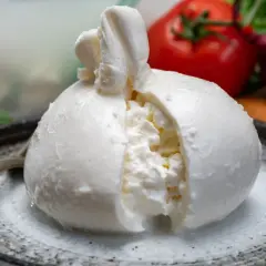 Pyszna burrata na talerzu, z pomidorem i cebulą w tle. Zastanawiasz się nad burrata kcal?