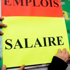 Ręce przyklejają plakaty z napisem "SALAIRE" (płaca). Ludzie walczą o najlepsze zarobki w Europie.