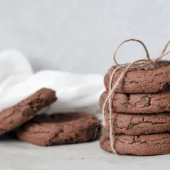 Stos ciastek czekoladowych związany sznurkiem, obok kilka pojedynczych ciastek.