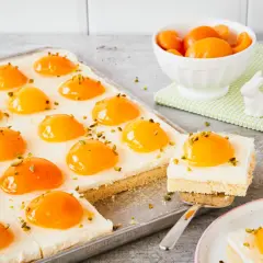 Ciasto z kremem i brzoskwiniami, przypominające jajko sadzone. Posypane pistacjami.