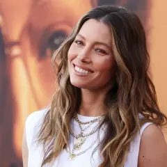 Jessica Biel sonríe con su pelo liso y mechas balayage, luciendo un collar de varias cadenas.