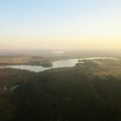 Widok z lotu ptaka na zalew przeczycko-siewierski otoczony lasami i polami.