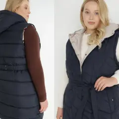 Dwie modelki plus size prezentują granatową, pikowaną kamizelkę z kapturem i paskiem.