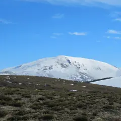 El pico más alto de Almería, cubierto de nieve, se alza majestuoso bajo un cielo azul despejado.