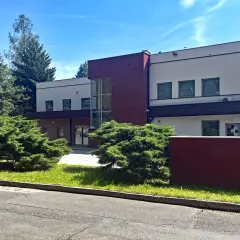 Nowoczesny budynek Ośrodka Pomocy Społecznej w Jastrzębiu-Zdroju otoczony zielenią.
