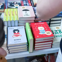 Na półce stoją książki, m.in. "Kobieta dość doskonała" i "Furia maći". Zastanawiasz się, ile zarabia autor na jednej sprzedanej książce procenty i tantiemy?