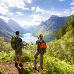 Trekking co to? Dwóch turystów z plecakami podziwia malowniczy fiord i góry.