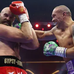 Two boxers clash in the highest weight class in boxing. Sweat flies as one lands a powerful punch, the other defends.