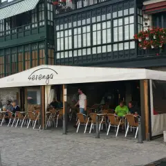 Gente disfrutando de un día soleado para comer en Lekeitio, sentados en las mesas de un restaurante con toldo blanco.