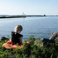 Flicka i tyllkjol vid vattnet nära ett vandrarhem i Mariestad.