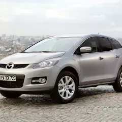 Srebrna Mazda CX-7 2.3 Turbo na tle panoramy miasta.