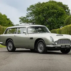 Srebrny Aston Martin DB5 Shooting Brake na tle zieleni. Klasyk z lat 60. w unikalnej wersji kombi.