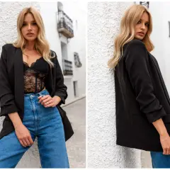 Kobieta w czarnej marynarce oversize i koronkowej bieliźnie, jeansach. Stylowe czarne marynarki oversize stylizacje.