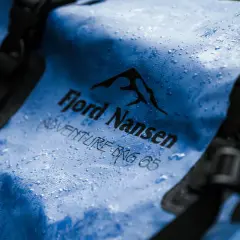Niebieska torba Fjord Nansen Adventure Bag 65 z kropelkami wody. Waterproof to znaczy, że nic jej nie straszne.