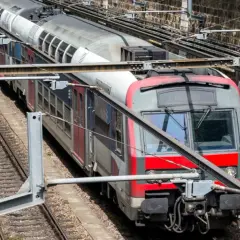 Pociąg RER A w Paryżu na torach, z widocznymi elementami infrastruktury kolejowej.