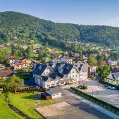 Widok na Hotel Skalite Spa & Wellness w Szczyrku, otoczony zielonymi wzgórzami i malowniczą zabudową.