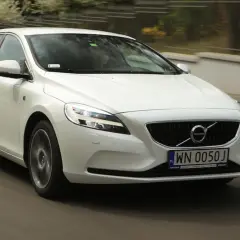 Białe Volvo V40 D2 w ruchu miejskim, z widocznym numerem rejestracyjnym WN 0050J.