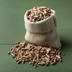 Worek z pelletem na zielonym tle. Zastanawiasz się, ile waży worek pelletu?