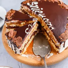 Pyszny tort snickers z czekoladą i orzeszkami, pokrojony na kawałki, gotowy do podania.