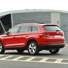 Czerwona Skoda Kodiaq w ruchu. Wiele pozytywnych skoda kodiaq opinie potwierdza jej wszechstronność.