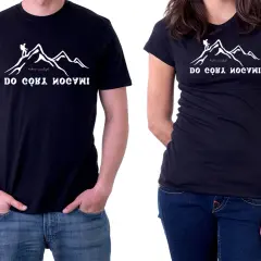 Dwie czarne koszulki z nadrukiem gór i turysty.