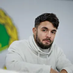 Anthony Yigit, en svensk boxare, blickar mot kameran i en ljus studio.