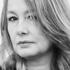 Svartvitt porträtt av Åsa Linderborg, med fokus på hennes ansikte och blonda hår som faller över axeln.
